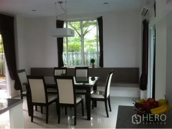 Detached House for rent in Saphan Sung, Bangkok - Dining area with six-seat table beside a large window and built-in bench seating.