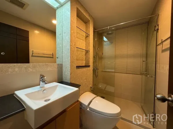 คอนโด ให้เช่าในPathum Wan, Bangkok - ห้องน้ำโมเดิร์นพร้อมตู้ฝักบัวกระจก อ่างล้างหน้า และชั้นวางผนัง