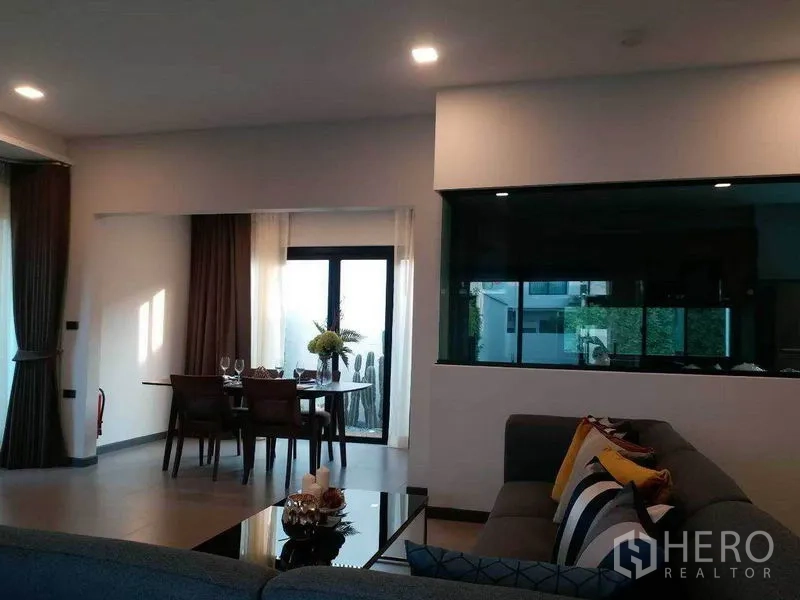 Townhouse for rent in Bang Phli, Samut Prakan - Modern living room with glass partition and a dining nook beside sliding doors to the terrace.