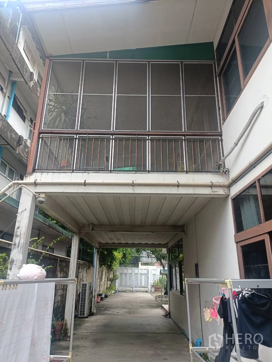 Detached House for rent in Bang Rak, Bangkok - Covered driveway and carport beneath a screened balcony leading to the rear gate.