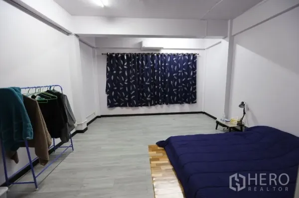 店屋 出租或出售在Watthana, Bangkok - 大卧室/工作室，灰色地面，深蓝窗帘，地铺床与衣架