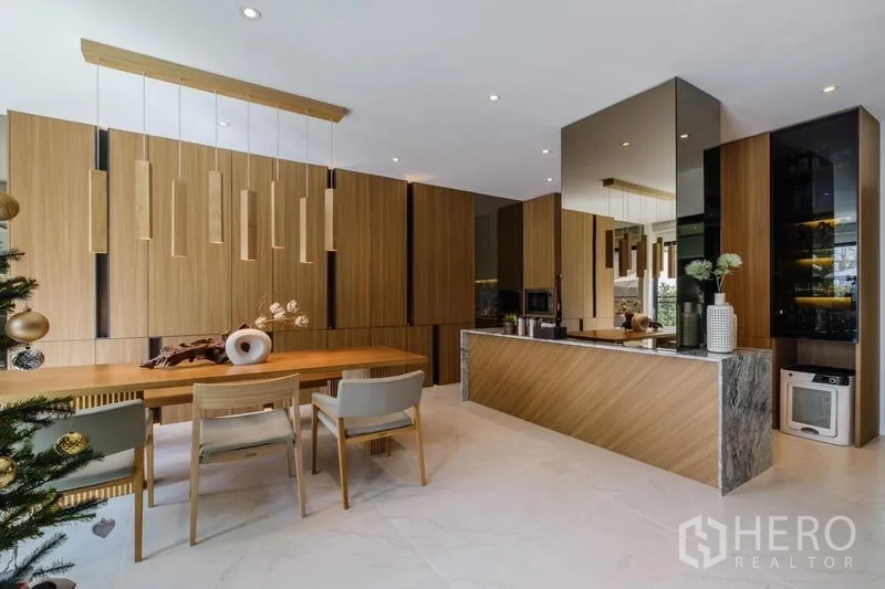 Detached House for rent in Phasi Charoen, Bangkok - Dining area and island kitchen with pendant lights and marble surfaces.
