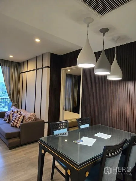 Condominium for rent - Dining corner with three pendant lights and a dark wood feature wall.