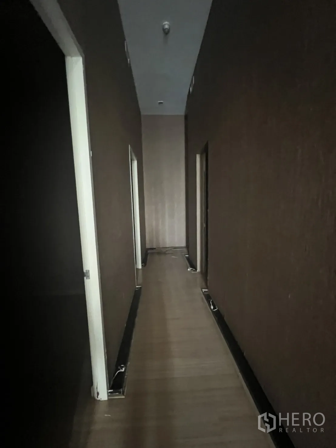 零售空间 出租在Watthana, Bangkok - 走廊视角，数个房门与筒灯，木纹地面。