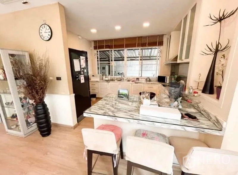 Detached House for rent in Bang Phli, Samut Prakan - Open kitchen with marble breakfast bar, stools, ample cabinetry and recessed lighting.