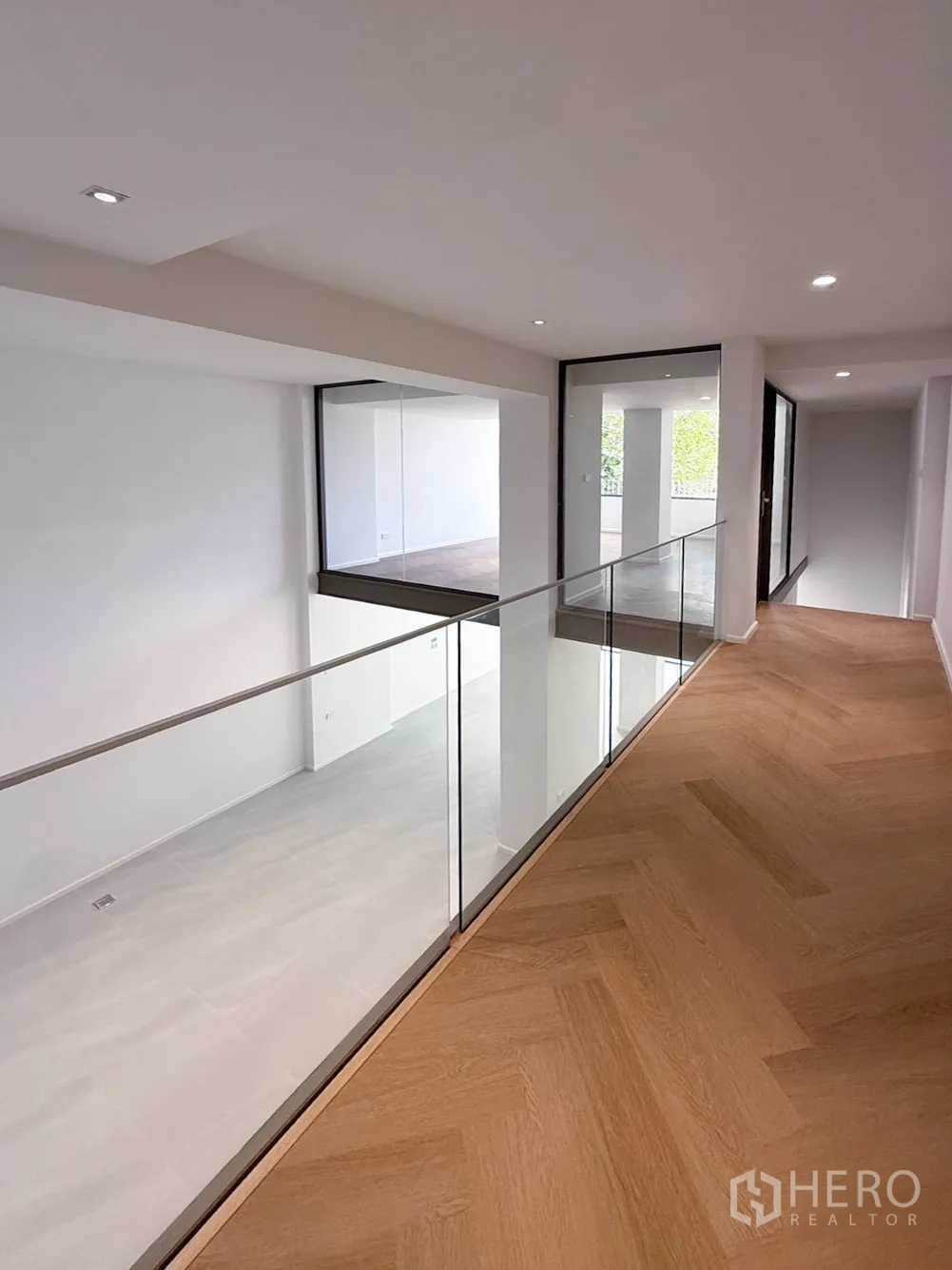 家庭办公室 for rent or sale in Watthana, Bangkok - 夹层走道玻璃栏杆，俯瞰挑高空间。