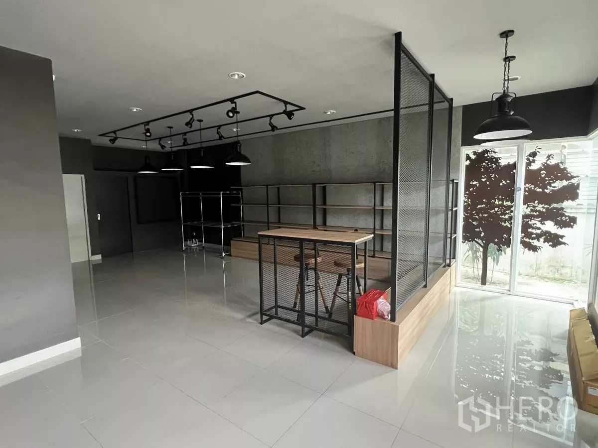 Detached House for rent or sale in Don Mueang, Bangkok - Retail‑style space with wood counter, mesh partition and sliding glass door to garden.