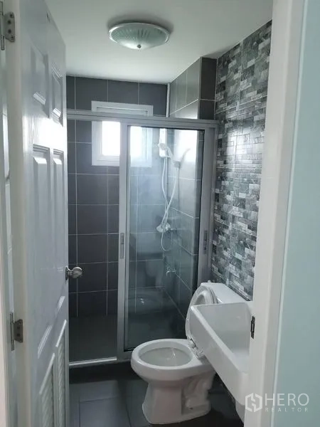 联排别墅 出租在Bang Kapi, Bangkok - 现代浴室，灰色瓷砖与玻璃淋浴房