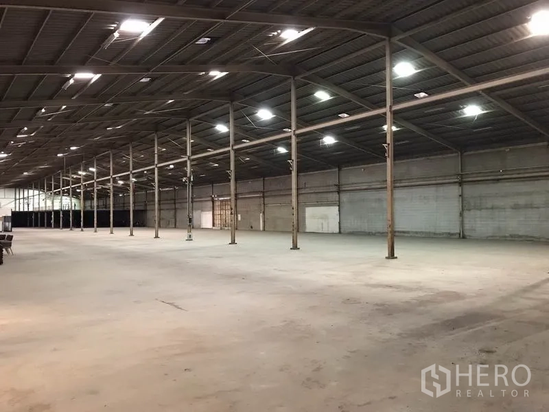 Warehouse for rent in Mueang Samut Sakhon, Samut Sakhon - Industrial interior with steel trusses, ventilation windows and bright lighting.