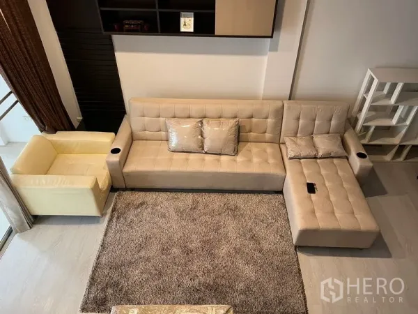 ทาวน์เฮาส์ ให้เช่าในSaphan Sung, Bangkok - มุมมองจากด้านบนของโซฟา L สีเบจบนพรมขนนุ่มในมุมนั่งเล่น