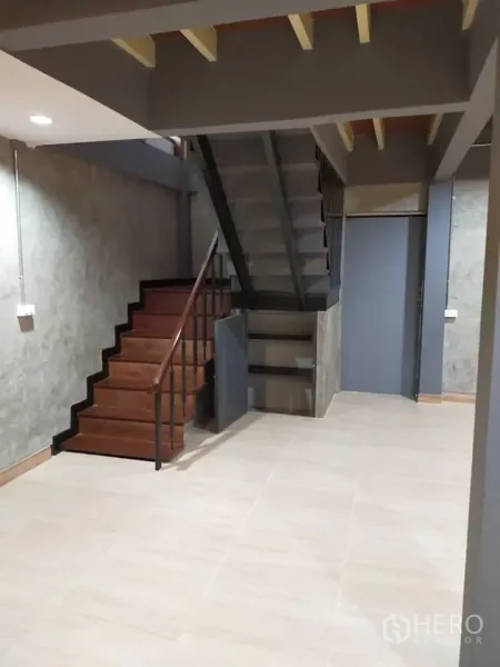 Detached House for rent in Watthana, Bangkok - Stair hall with wooden steps, under-stair storage cabinet, tiled floor and modern gray walls.
