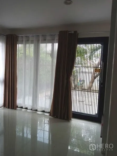 บ้าน ให้เช่าในChok Chai, Nakhon Ratchasima - ห้องนั่งเล่นสว่างพร้อมหน้าต่างกระจกเต็มบาน ผ้าม่านโปร่งและทึบ และประตูเหล็กนิรภัยมองออกสู่สวน