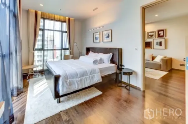 Condominium for rent or sale in Watthana, Bangkok - Bright bedroom with large windows, city view and soft curtains, adjoining the living room.