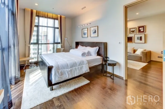 Condominium for rent or sale in Watthana, Bangkok - Bright bedroom with large windows, city view and soft curtains, adjoining the living room.