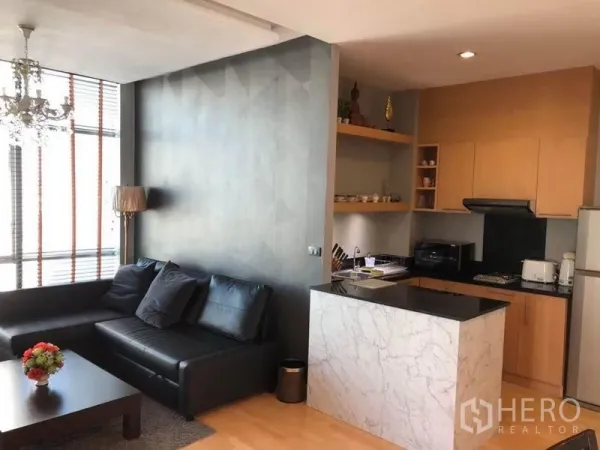 คอนโด ให้เช่าในKhlong San, Bangkok - ห้องนั่งเล่นแบบเปิดโล่ง โซฟาหนังสีดำ โคมระย้า และครัวเคาน์เตอร์ลายหินอ่อน