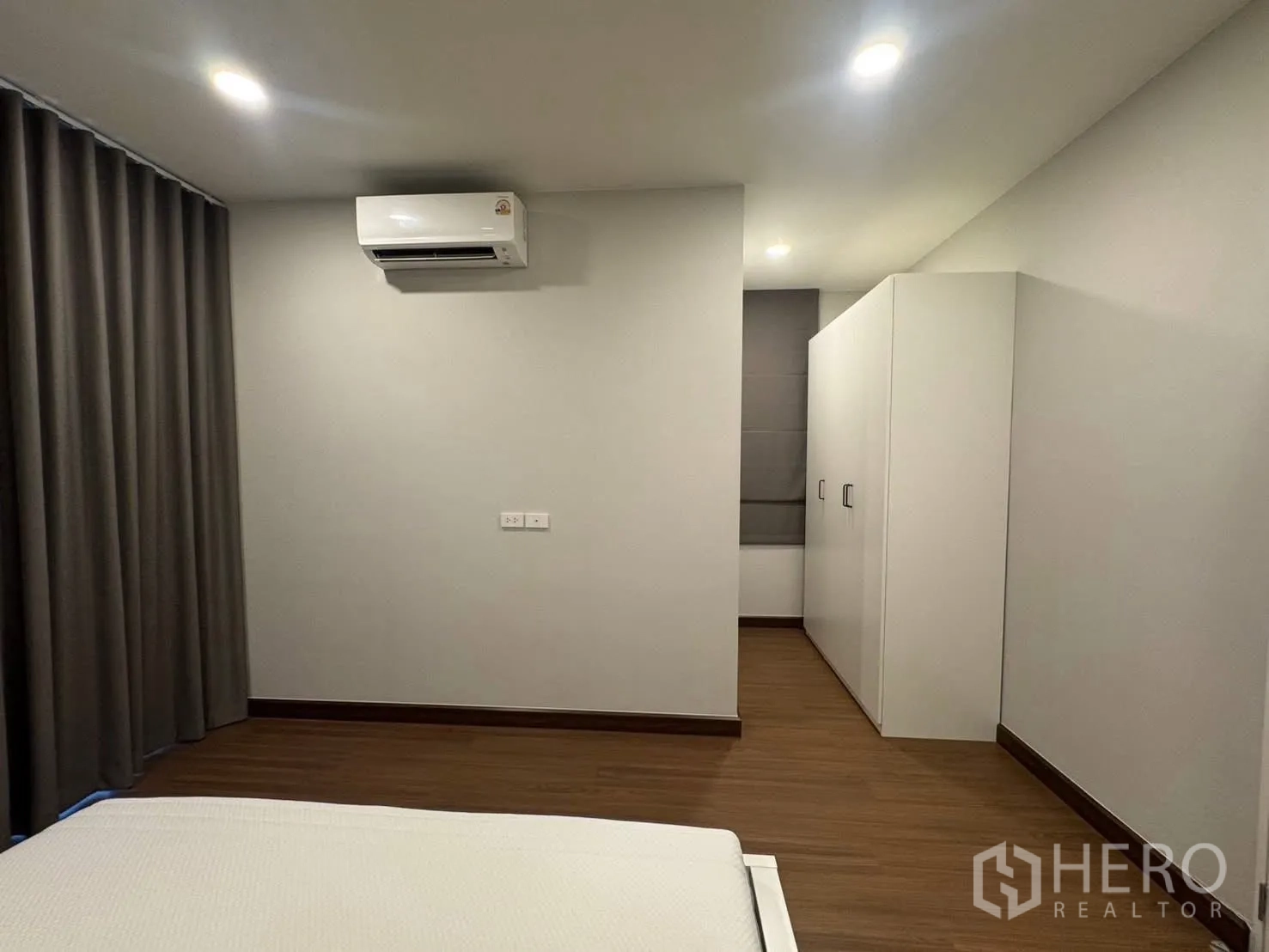 Detached House for rent in Bang Phli, Samut Prakan - Bedroom with air conditioner, wood flooring, and white wardrobe.