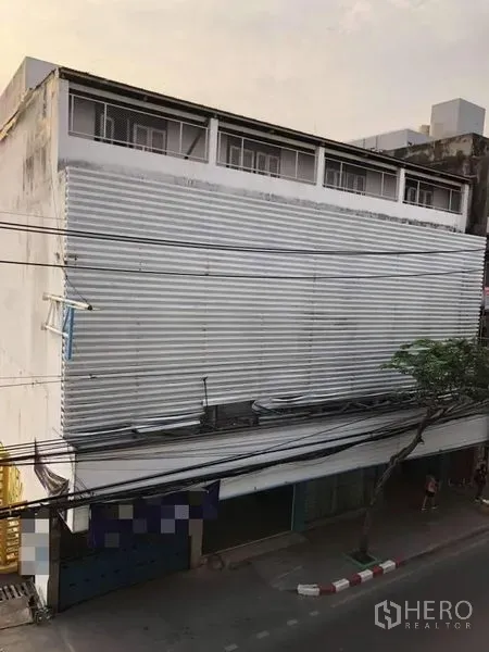 店屋 出租在Phra Khanong, Bangkok - 临街多层店屋外观，波纹金属立面与上层窗户。