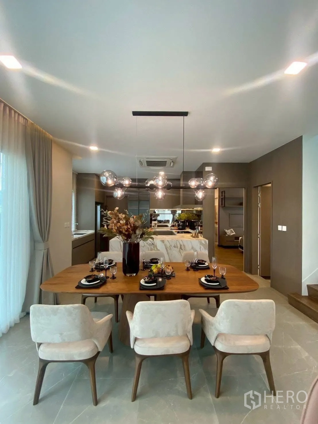 Detached House for rent in Bang Phli, Samut Prakan - Dining area set for six with modern chandelier and view to kitchen.