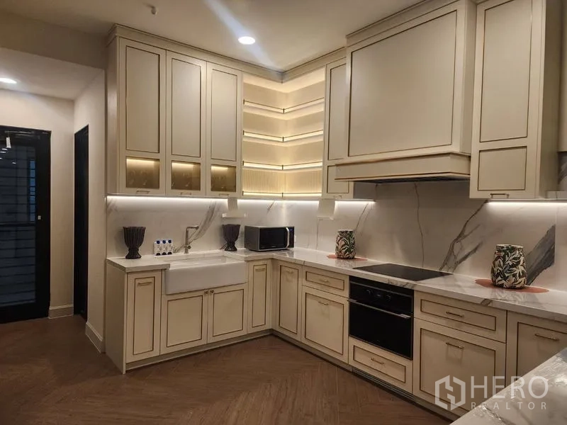 Detached House for rent or sale - Modern L-shaped kitchen with cream cabinetry, marble backsplash, induction hob and farmhouse sink