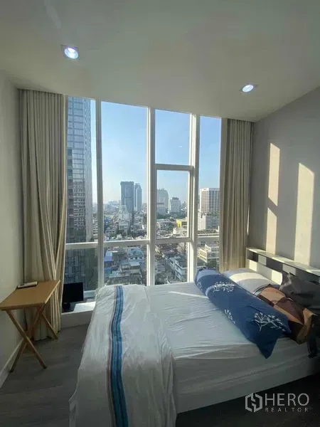 คอนโด ให้เช่าหรือขายในBang Rak, Bangkok - ห้องนอนสว่างด้วยหน้าต่างสูงจากพื้นจรดเพดาน มองเห็นวิวสกายไลน์กรุงเทพฯ