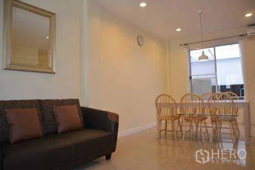 Home Office for rent in Wang Thonglang, Bangkok - Living corner with sofa and six-seat dining set under pendant light near a window in Wang Thonglang.