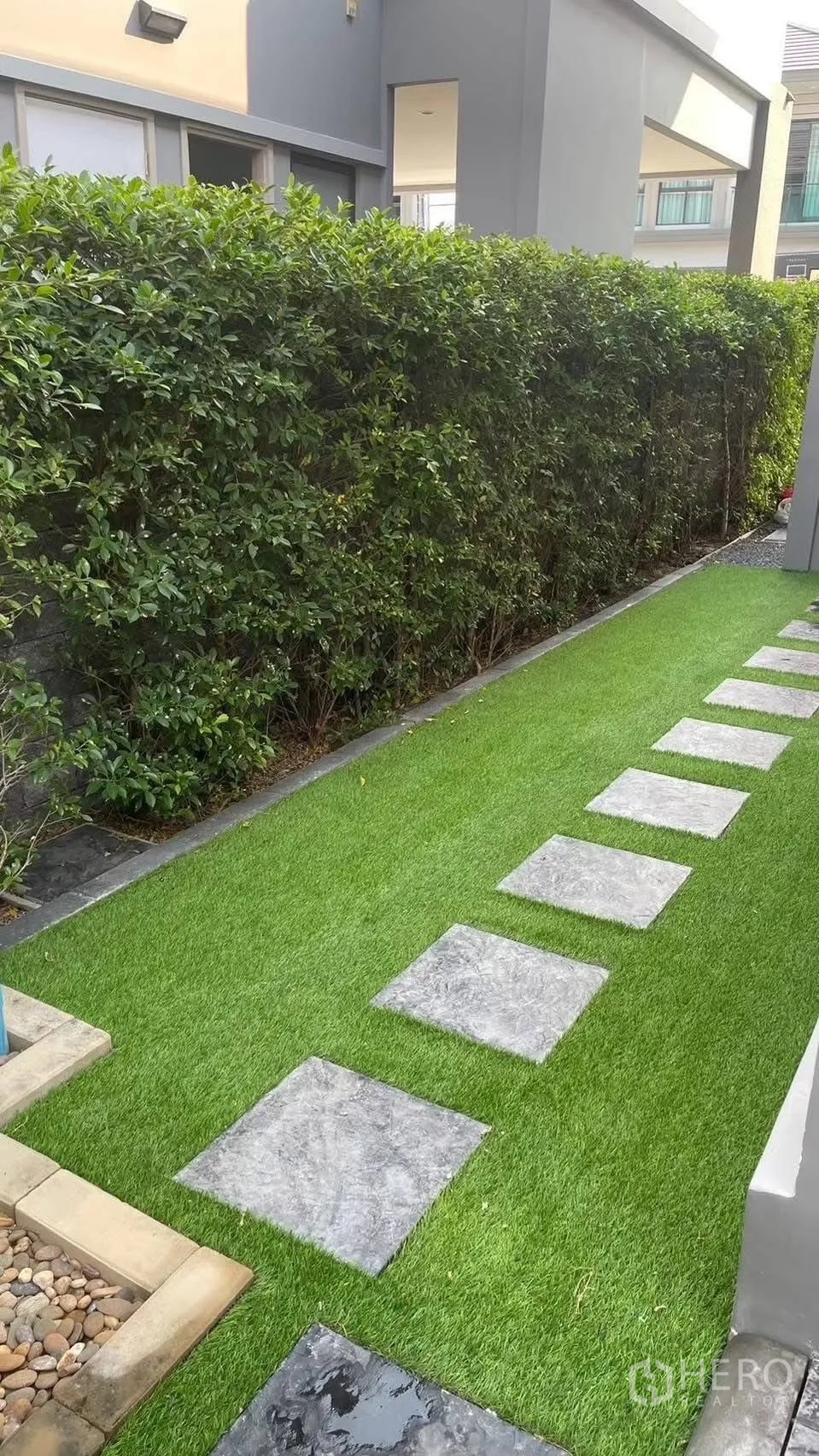 Detached House for rent in Prawet, Bangkok - Narrow lawn garden with stepping stones and tall hedge for privacy.