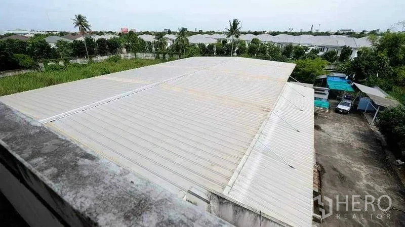 Warehouse for rent in Bang Kruai, Nonthaburi - Aerial view of the corrugated warehouse roof and surrounding greenery.