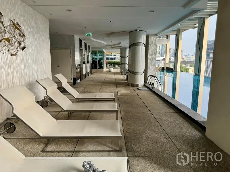 คอนโด ขายในRatchathewi, Bangkok - ดาดฟ้าพักผ่อนข้างสระพร้อมเตียงอาบแดด