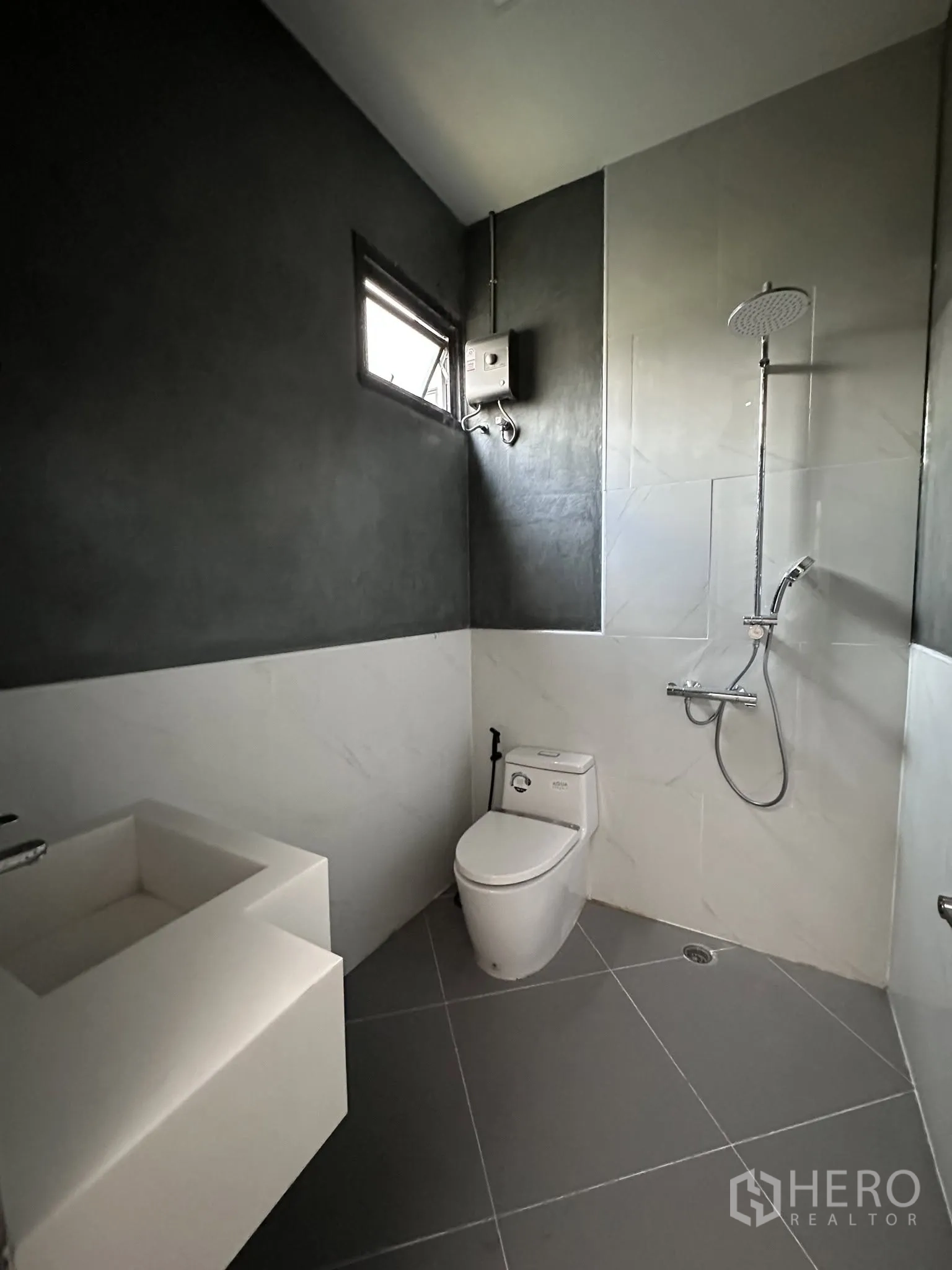 Warehouse for rent or sale in Prawet, Bangkok - Bathroom with toilet, sink and wall-mounted shower unit.