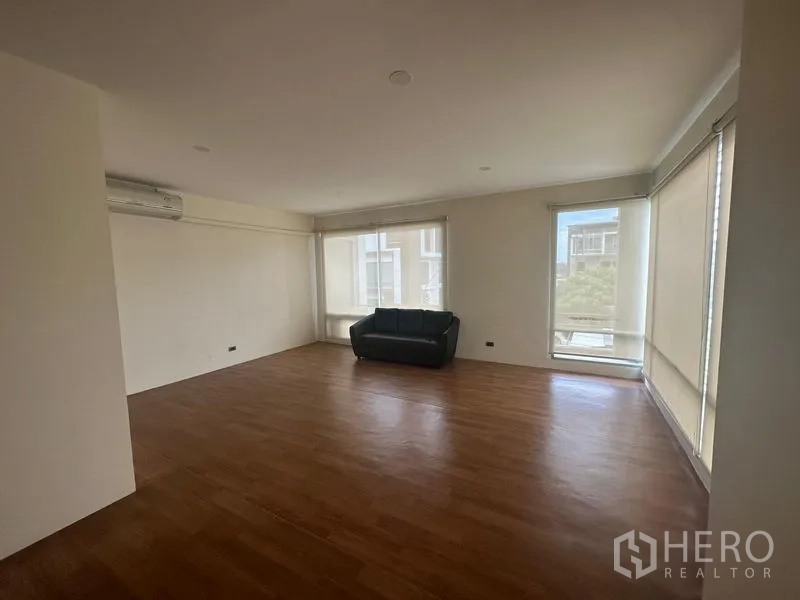 สำนักงานที่บ้าน ให้เช่าในWang Thonglang, Bangkok - ห้องนั่งเล่นกว้าง พื้นไม้ ม่านม้วน และโซฟาสีดำ