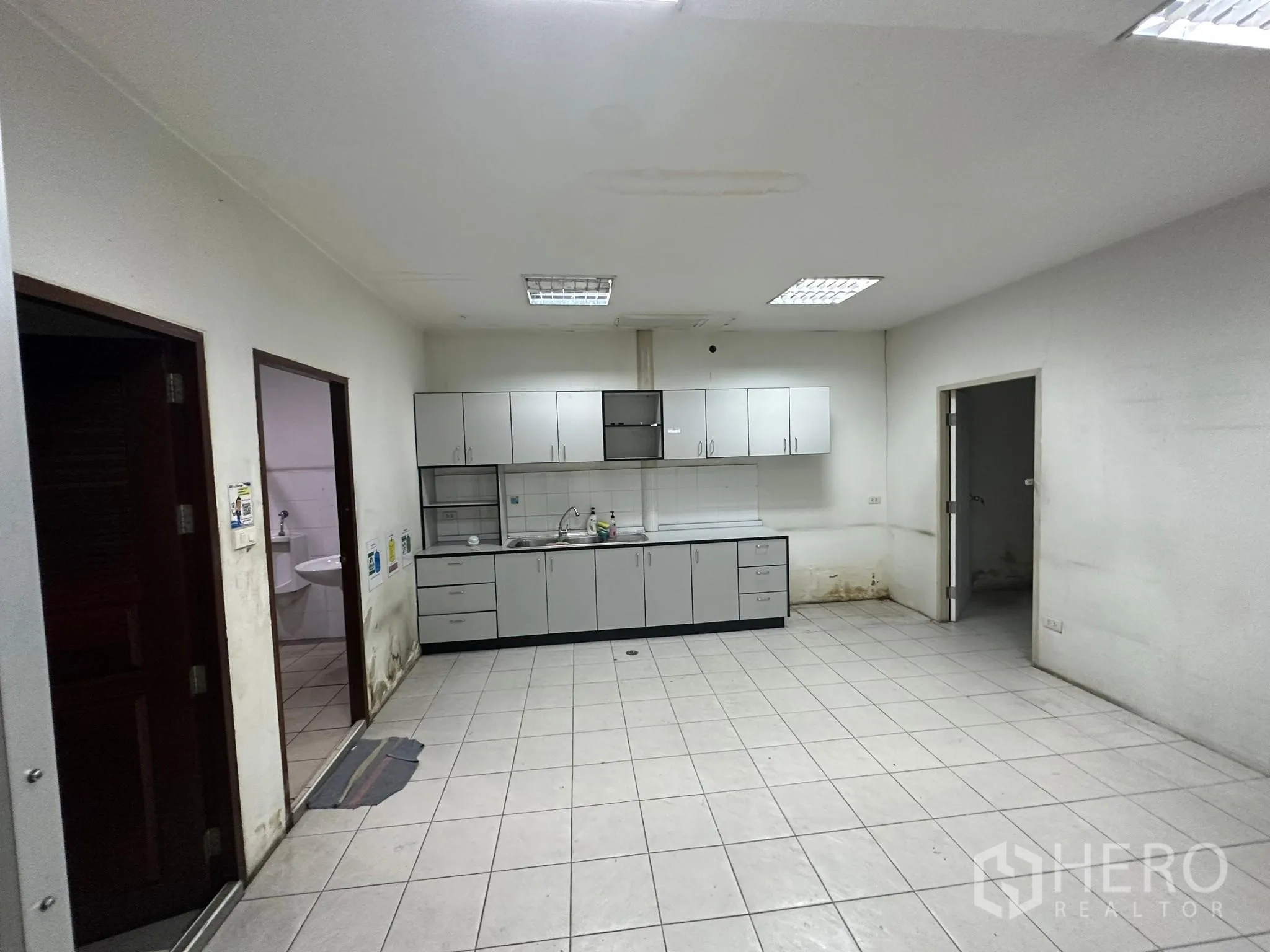 Warehouse for rent in Huai Khwang, Bangkok - Pantry with built-in cabinets, sink and tiled floor.