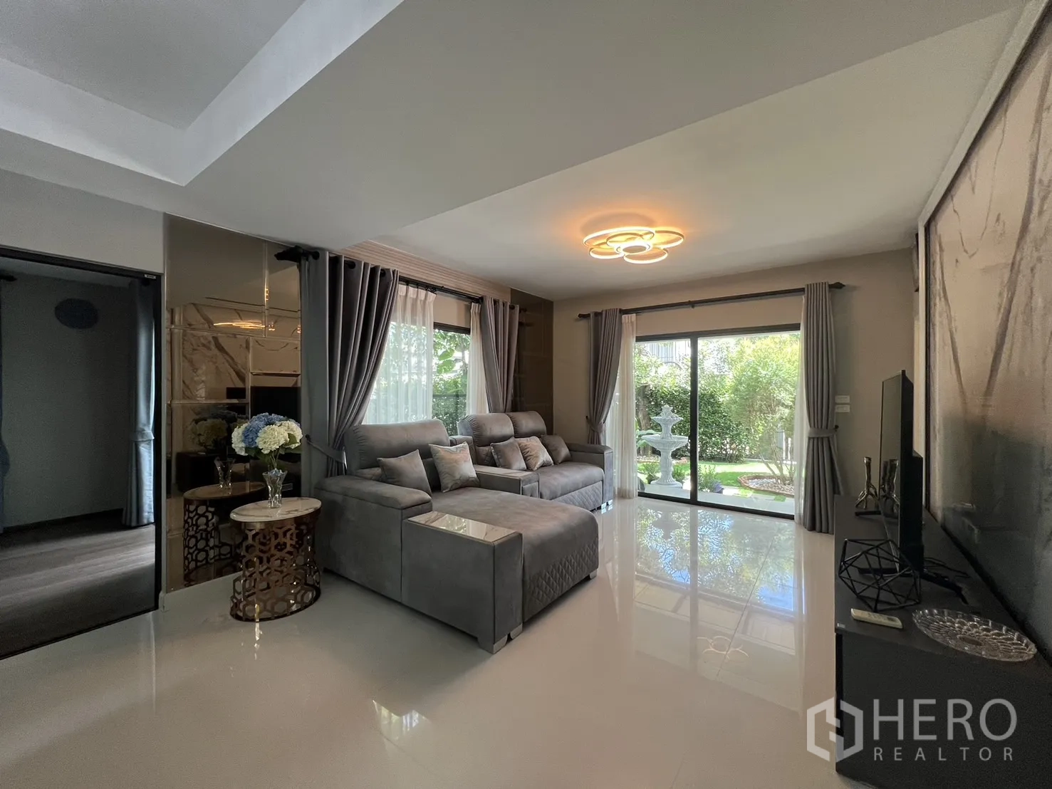 Detached House for rent in Bang Phli, Samut Prakan - Living area with sliding glass doors opening to the garden and a feature ceiling light.