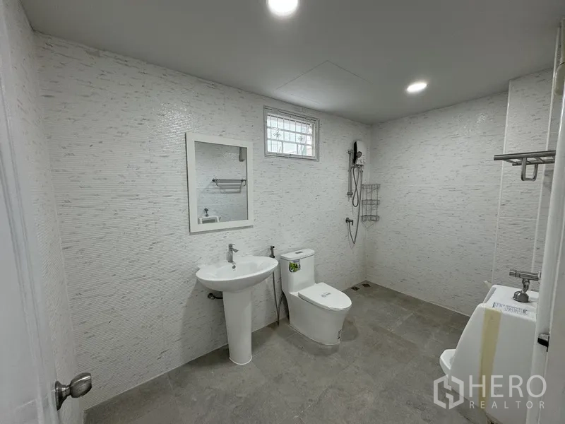 Townhouse for sale in Bueng Kum, Bangkok - Second bathroom with small window, shower, toilet and white tiled walls.