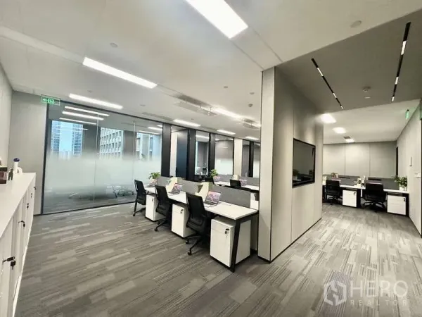 สำนักงาน ให้เช่าในBang Kapi, Bangkok - มุมสำนักงานที่มีโต๊ะสองฝั่ง ผนังกระจกมองเห็นวิวเมือง และจอแสดงผลติดผนัง