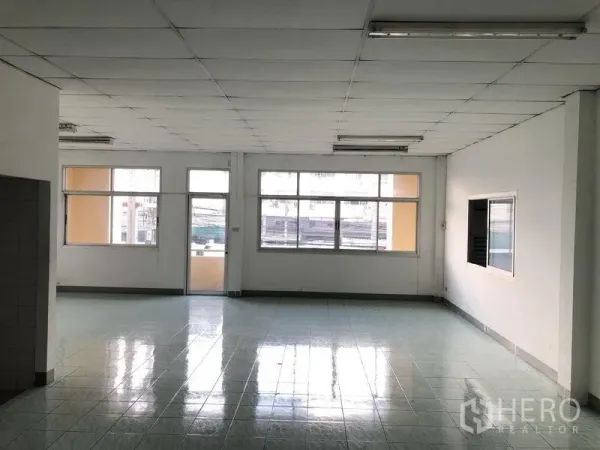 Factory for rent in Pathum Thani - Bright upper-floor office with large windows and glossy tiled floor.