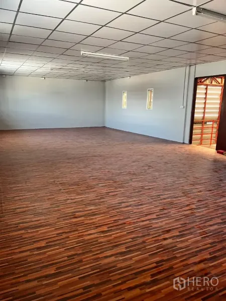 Warehouse for rent in Lat Lum Kaeo, Pathum Thani - Upstairs office room with drop ceiling and wood-pattern vinyl flooring.