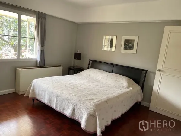 公寓 出租在Watthana, Bangkok - 温馨主卧，大片窗户、双人床与灰色墙面。