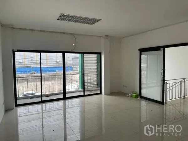 Factory for rent or sale in Bang Phli, Samut Prakan - Bright upper office with large sliding glass doors opening to a small balcony.