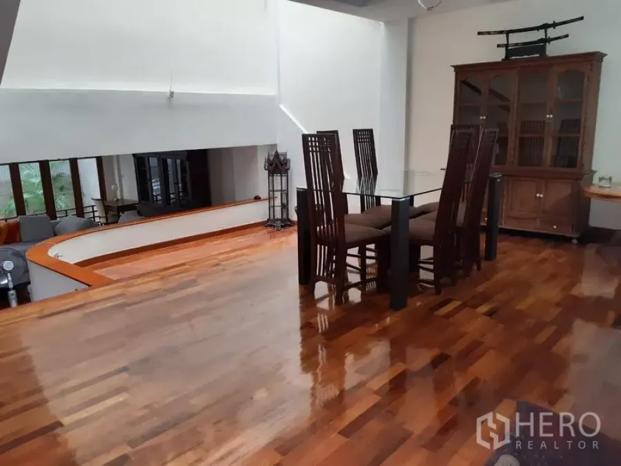 ทาวน์เฮาส์ ให้เช่าในWatthana, Bangkok - พื้นที่รับประทานอาหารแบบยกระดับ โต๊ะกระจก เก้าอี้พนักพิงสูง ตู้โชว์ไม้ เพดานสูง และพื้นไม้ขัดมัน