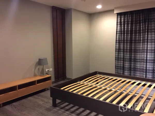 คอนโด ให้เช่าหรือขายในWatthana, Bangkok - ห้องนอนกว้างพร้อมโครงเตียง ตู้วางของ โคมไฟ และผ้าม่านลายตารางบนพื้นไม้