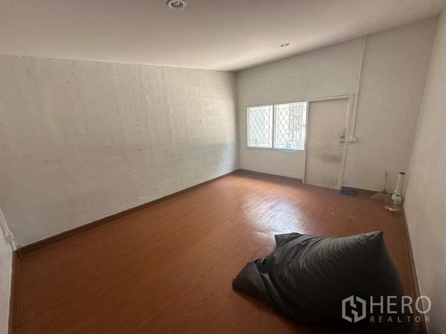 Warehouse for rent in Din Daeng, Bangkok - Multi-purpose room with wood flooring and a barred window.