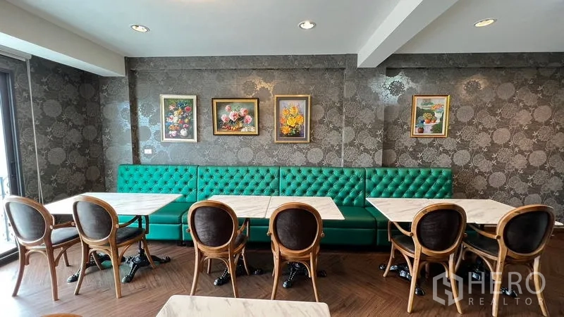 อาคารพาณิชย์ ให้เช่า - โซนรับประทานอาหารพร้อมเบาะยาวสีเขียวมรกตและโต๊ะหินอ่อน