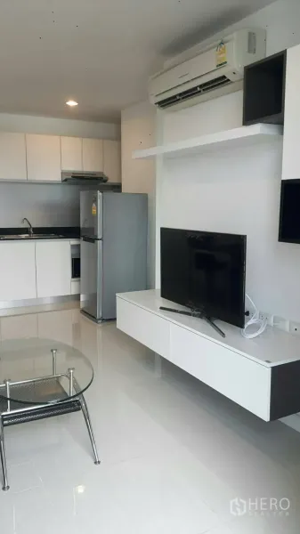 公寓 出租在Phaya Thai, Bangkok - 开放式客厅连接紧凑厨房，配电视柜与不锈钢冰箱。