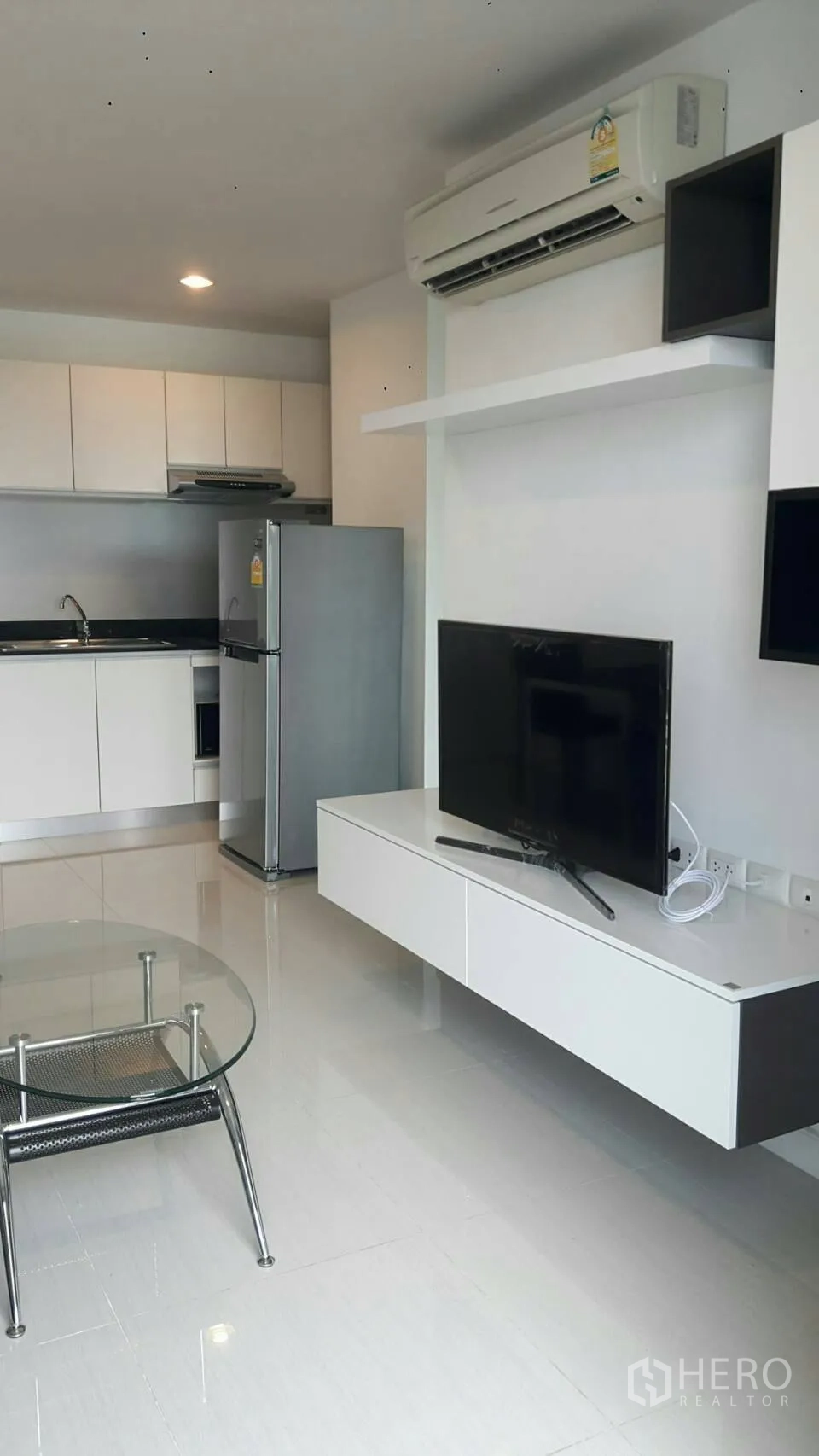 公寓 出租在Phaya Thai, Bangkok - 开放式客厅连接紧凑厨房，配电视柜与不锈钢冰箱。