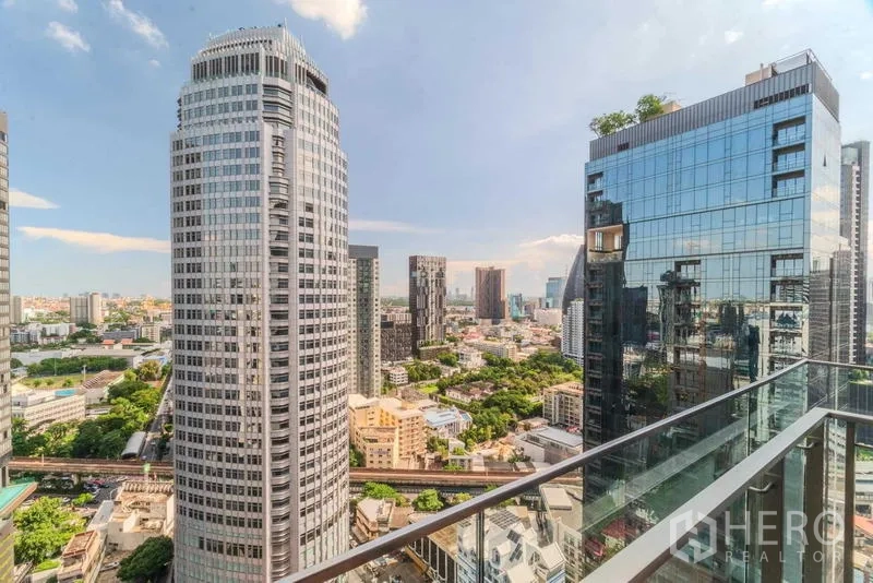 Condominium for rent or sale - Balcony with glass railing looking out to nearby high-rise towers.