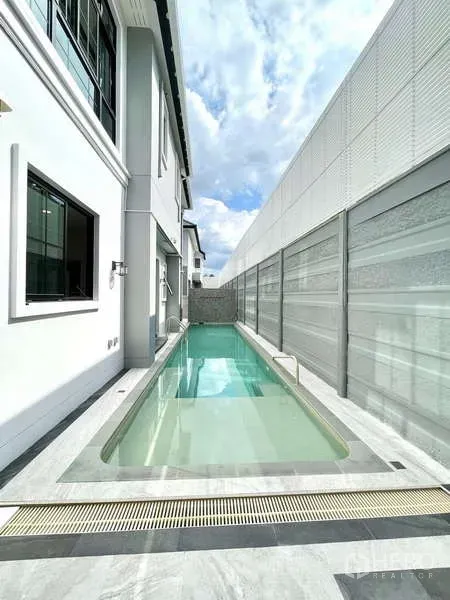 Detached House for sale in Thawi Watthana, Bangkok - Slim private lap pool along the side yard with modern privacy wall