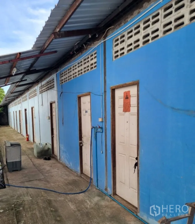 คลังสินค้า for sale in Bang Bon, Bangkok - แถวห้องพักพนักงานสีฟ้าพร้อมทางเดินภายนอกมีหลังคา