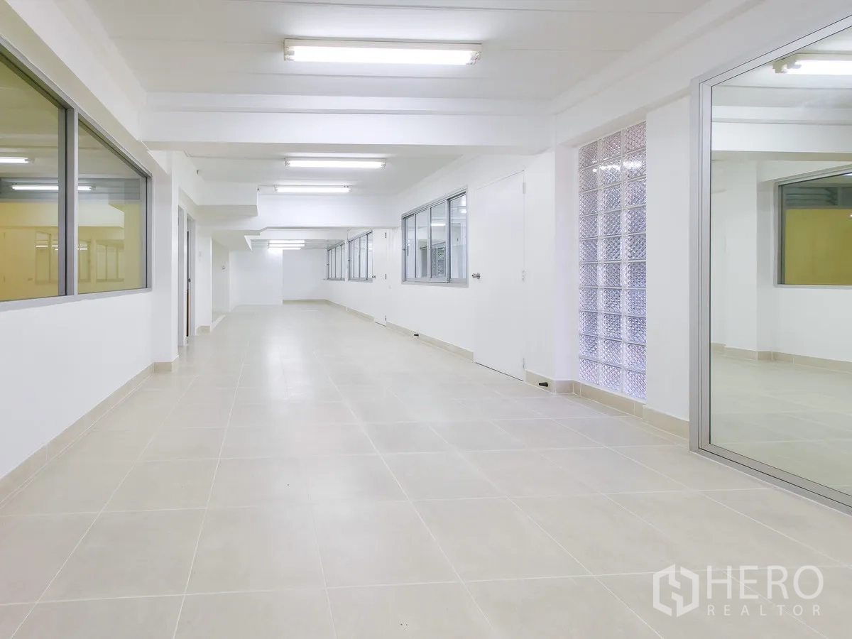 办公室 for rent in Khlong Toei, Bangkok - 走廊式办公区，有玻璃砖装饰墙和多扇窗户。