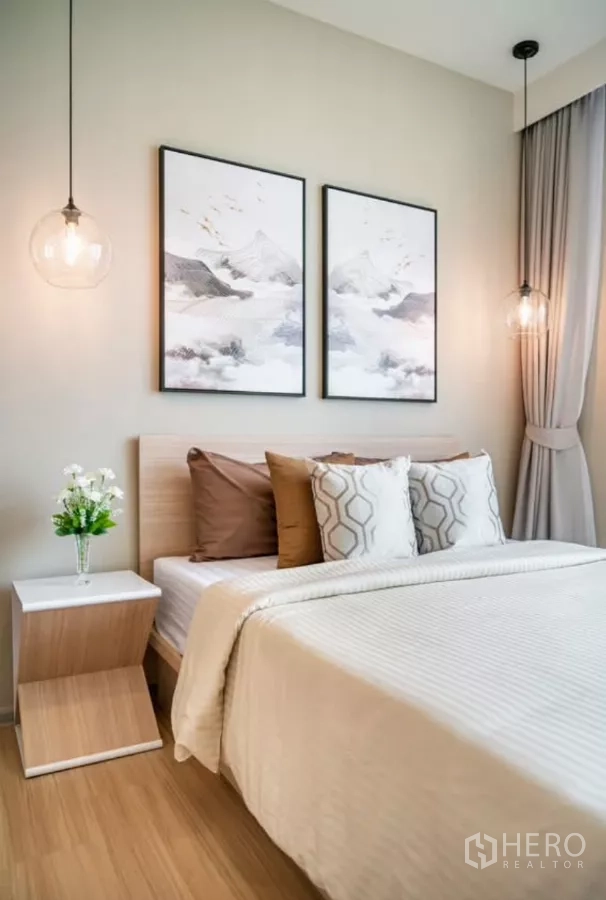 คอนโด ให้เช่าในChatuchak, Bangkok - ภาพใกล้เตียงห้องนอนหลัก ชุดเครื่องนอนโทนอบอุ่น โต๊ะข้างเตียง และโคมไฟแก้วห้อย.