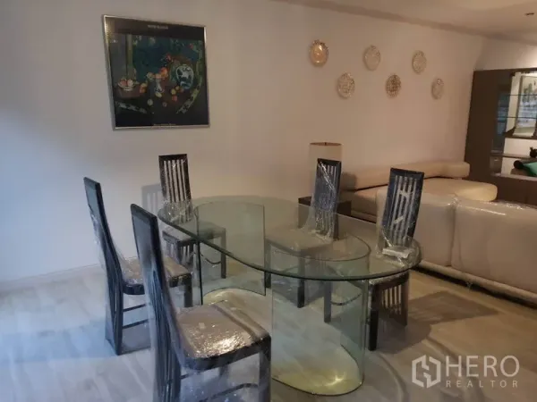 ทาวน์เฮาส์ ให้เช่าในKhlong Toei, Bangkok - พื้นที่ทานอาหาร โต๊ะกระจกทรงรี เก้าอี้หกตัว และงานศิลป์บนผนัง